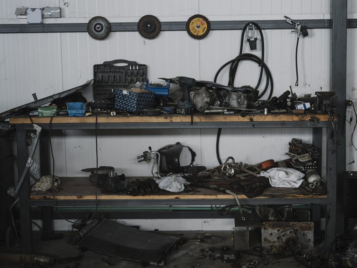 Garage workbench with parts and tools sorted on two shelves. Photo: Shixart1985, CC BY 2.0, via Wikimedia Commons