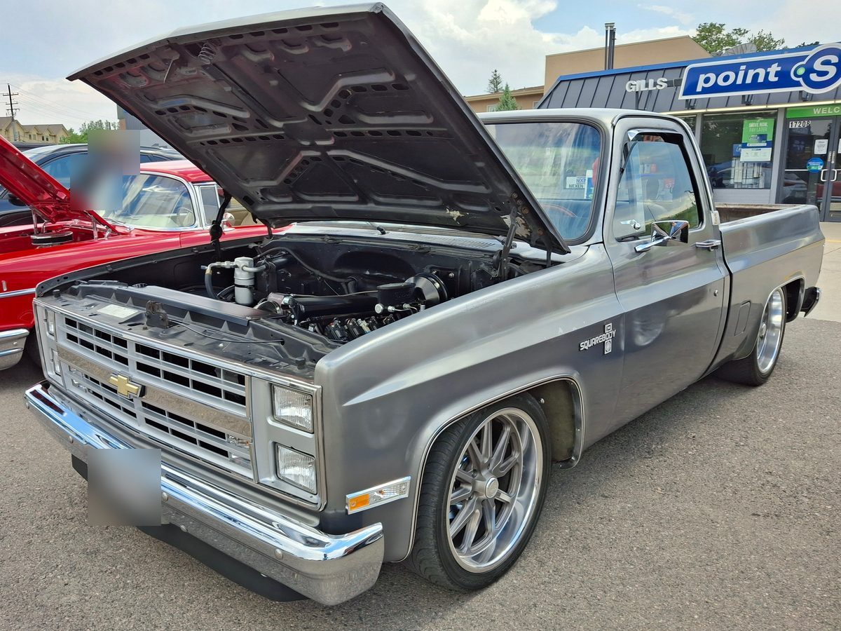 Grey 1981 to 1987 Chevrolet C10 squarebody with the hood up at a cruise night. Plate blurred. Photo: Xnatedawgx, CC BY-SA 4.0, via Wikimedia Commons